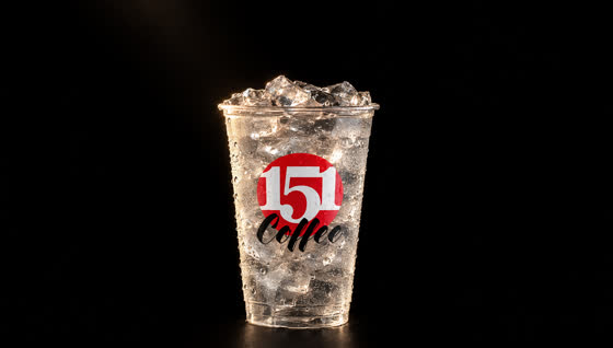 A clear iced 151 cup alone on a black stage